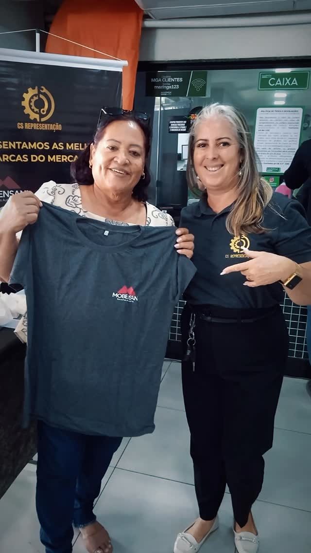 Cliente recebendo camisa da Mobensani em loja de autopeças